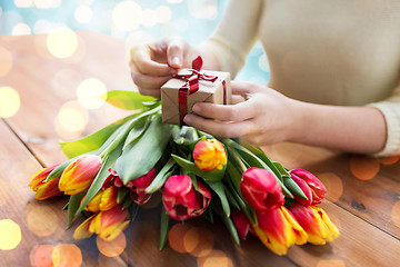 Image showing close up of woman with gift box and tulip flowers