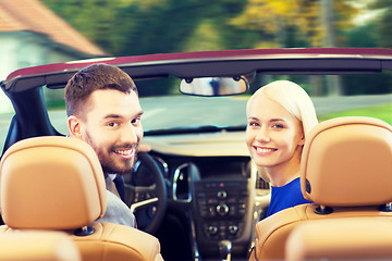 Image showing happy couple driving in cabriolet car over city