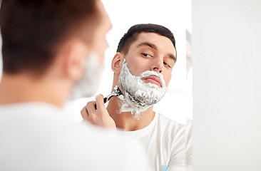 Image showing man shaving beard with razor blade at bathroom