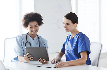 Image showing happy doctors with tablet pc meeting at hospital