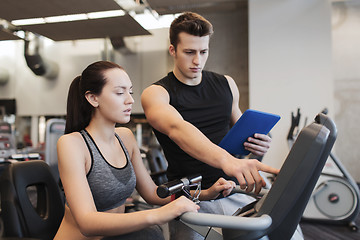 Image showing woman with trainer on exercise bike in gym