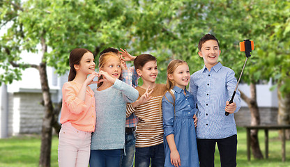 Image showing happy children with smartphone and selfie stick