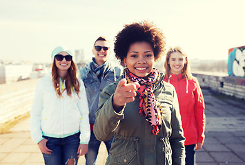 Image showing happy friends pointing finger to you on street