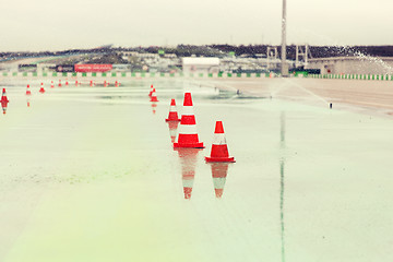 Image showing traffic cones and sprinklers on wet speedway