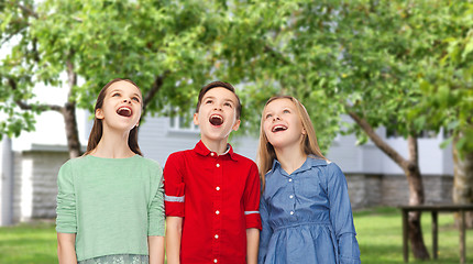 Image showing amazed boy and girls looking up over backyard