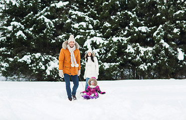 Image showing happy family with sled walking in winter forest