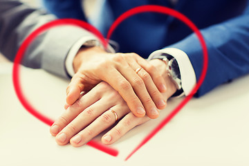 Image showing close up of gay couple hands with wedding rings on