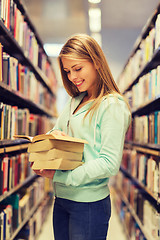 Image showing happy student girl or woman with book in library