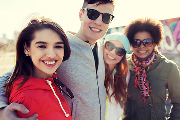 Image showing happy teenage friends in shades hugging outdoors