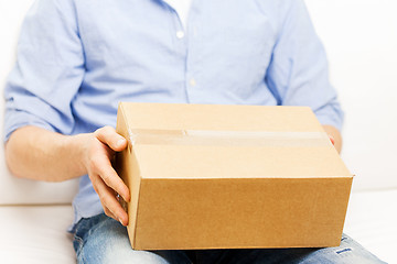 Image showing close up of man with cardboard box parcel at home