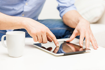 Image showing close up of man with tablet pc and tea cup at home
