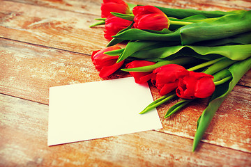 Image showing close up of red tulips and blank paper or letter