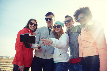 Image showing smiling friends taking selfie with smartphone