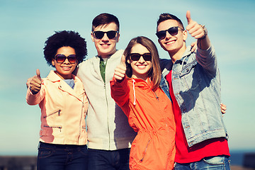 Image showing happy teenage friends in shades hugging outdoors