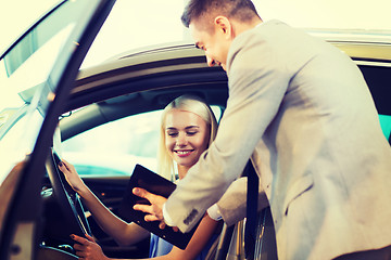 Image showing happy woman with car dealer in auto show or salon