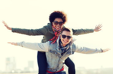 Image showing happy teenage couple in shades having fun outdoors