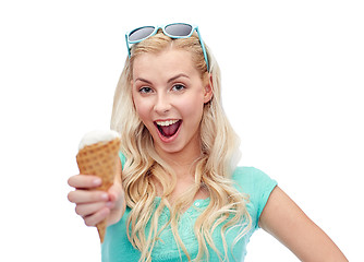 Image showing happy young woman in sunglasses eating ice cream