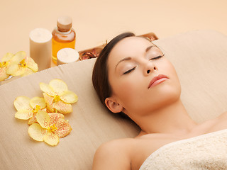 Image showing woman in spa salon lying on the massage desk