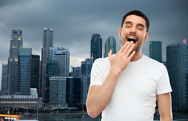 Image showing yawning man over evening singapore city background