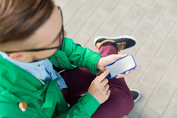 Image showing close up of man with smartphone sitting on bench