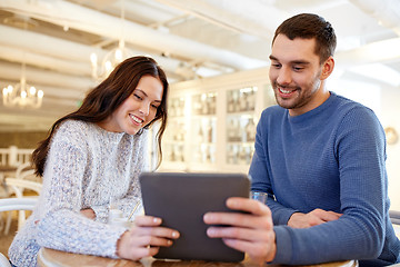 Image showing happy couple with tablet pc drinking tea at cafe