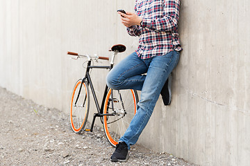Image showing close up of hipster man with smartphone and bike