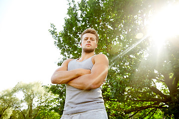 Image showing sporty young man with crossed arms at summer park