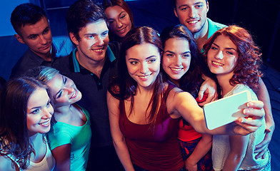 Image showing friends with smartphone taking selfie in club