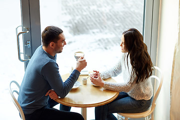 Image showing happy couple drinking tea and coffee at cafe