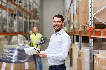 Image showing happy businessman with clipboard at warehouse