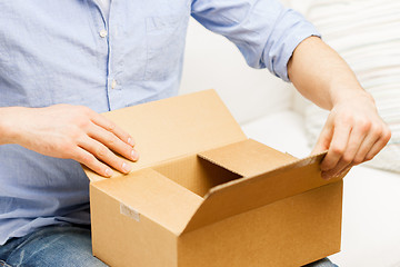 Image showing close up of man with cardboard box parcel at home