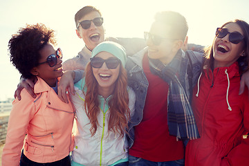 Image showing smiling friends in sunglasses laughing on street