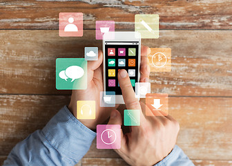 Image showing close up of male hands with smartphone on table