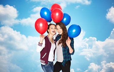 Image showing happy teenage girls with helium balloons over sky