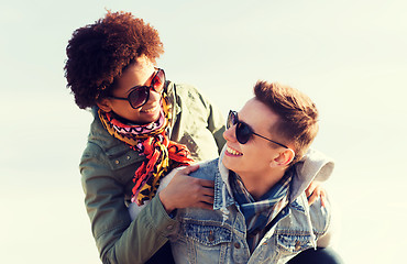 Image showing happy teenage couple in shades having fun outdoors