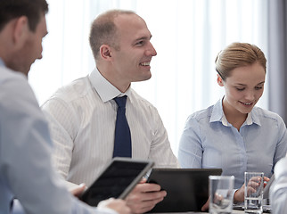 Image showing smiling businesspeople with tablet pc in office