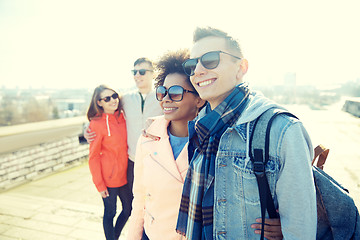 Image showing happy teenage friends in shades hugging on street