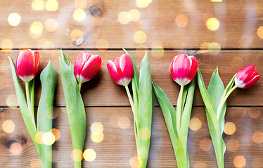 Image showing close up of red tulip flowers on wooden table