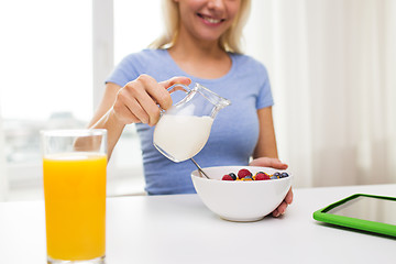 Image showing close up of woman with milk jug eating breakfast