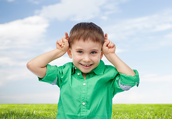 Image showing happy little boy having fun and making horns