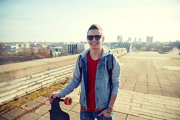 Image showing smiling man or teenager with longboard on street