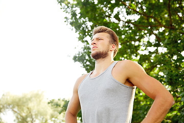 Image showing sporty young man with crossed arms at summer park