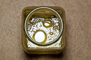 Image showing round oil drops in square jar