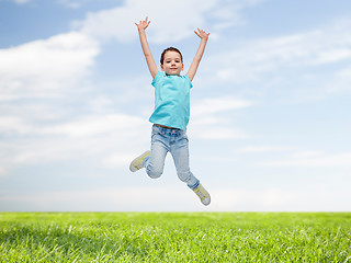Image showing happy little girl jumping in air