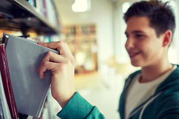 Image showing close up of happy student boy with book in library