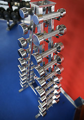 Image showing close up of dumbbells and sports equipment in gym