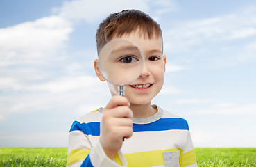 Image showing happy little boy looking through magnifying glass