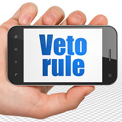 Image showing Political concept: Hand Holding Smartphone with Veto Rule on display