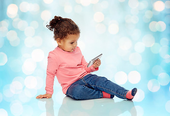 Image showing smiling little baby girl playing with smartphone
