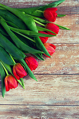 Image showing close up of red tulips on wooden background